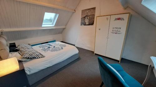 a small room with a bed and a blue chair at Un petit coin de paradis près de Rennes in Tresboeuf