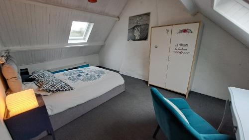 a small bedroom with a bed and a blue chair at Un petit coin de paradis près de Rennes in Tresboeuf