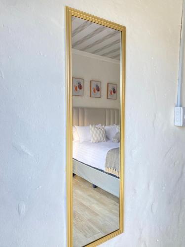 uno specchio che riflette un letto in una camera da letto. di Cozy corner a East London