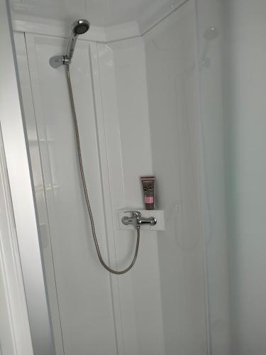 a shower with a hose attached to a white wall at Mobil home 8 pers dans Camping Siblu Les Rives de Condrieu in Condrieu