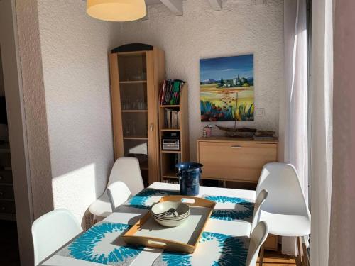 une salle à manger avec une table et des chaises blanches dans l'établissement Résidence Héliovillage - VILLA 4 pers. CAP d'AGDE MAE-1291, au Cap d'Agde
