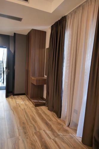 a room with wooden floors and curtains and a table at PineHill Hotel, Restaurant , Pool & Spa - RAZEM in Razëm