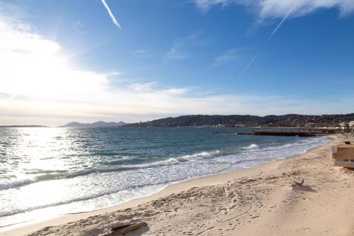 une plage de sable avec l'océan et une jetée dans l'établissement Beautiful and Cozy 3 bedrooms in Antibes, à Antibes
