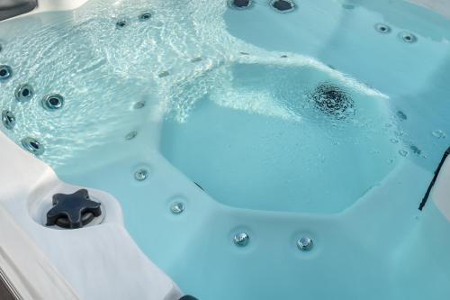 a dolphin swimming in a bath tub with blue lights at King Bed Exec Suite Hot Tub, Gym, Grill & Laundry in Kernersville