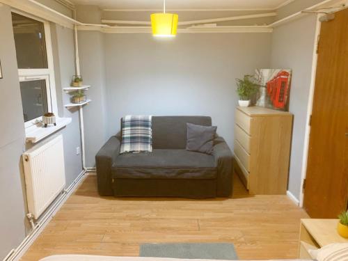 a living room with a couch in a room at Brixton/Oval House in London