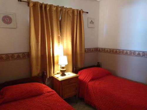a bedroom with two beds and a lamp on a table at Alojamiento Corcovado in El Corcovado