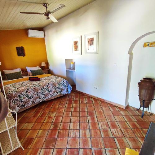 a bedroom with a bed and a tiled floor at Quinta Pereiro Tropic Garden, Algarve in Moncarapacho