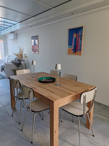 - une table en bois avec des chaises dans l'établissement Maison à 10 min de la plage, à Les Sables-dʼOlonne