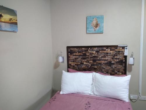 a bedroom with a bed with a brick wall at St. George's Holiday Studio Vacation of a lifetime in Fontenoy