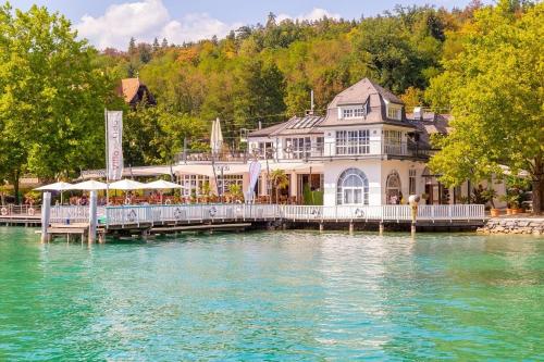 a large house on a dock on the water at Apartments Sunnseitn by Gerrit & Herfried in Krumpendorf am Wörthersee