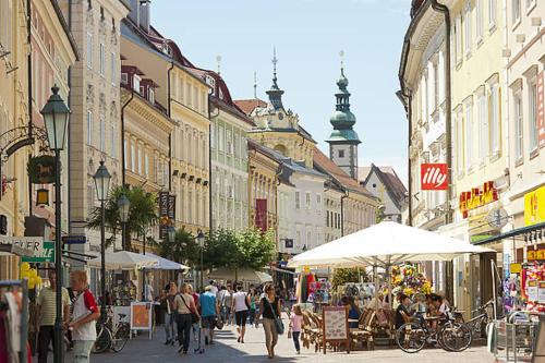 a group of people walking down a busy city street at Apartments Sunnseitn by Gerrit & Herfried in Krumpendorf am Wörthersee