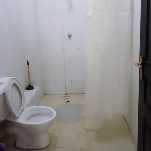 a bathroom with a white toilet in a room at Maggies suites and Bnb in Nairobi