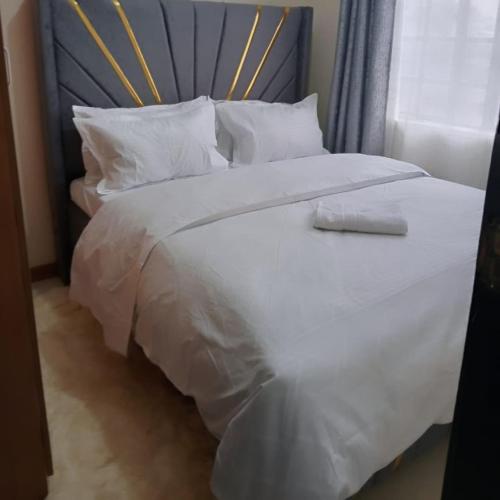 a large white bed with white sheets and pillows at Maggies suites and Bnb in Nairobi