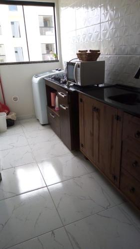 a kitchen with a sink and a microwave at Apto Tijucas lá vie in Tijucas
