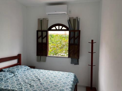 a bedroom with a bed and a window at Pousada Recanto do Japa in Nilo Peçanha