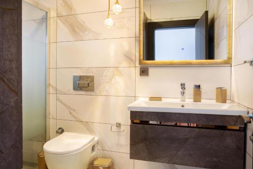 a bathroom with a toilet and a sink and a mirror at BD4108 Two Bedroomed Villa withPool inBodrumYalikavak in Bodrum City