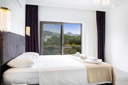 a bedroom with a white bed with a large window at BD4108 Two Bedroomed Villa withPool inBodrumYalikavak in Bodrum City
