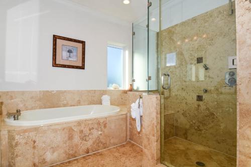 a bathroom with a tub and a glass shower at Casa Di Amore in Destin