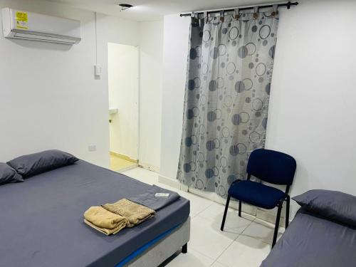 卡塔赫纳Habitación cerca a la playa 105的卧室里有一张床和一把椅子