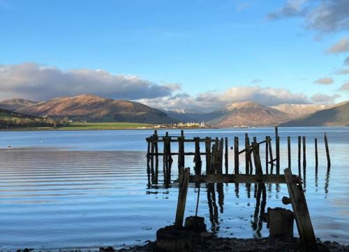 a dock in the middle of a body of water at Beautiful Upper Apartment/Stunning Sea Views, Isle of Bute in Port Bannatyne