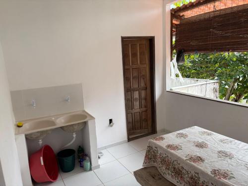 a bathroom with a sink and a mirror and a window at Pousada Recanto do Japa in Nilo Peçanha