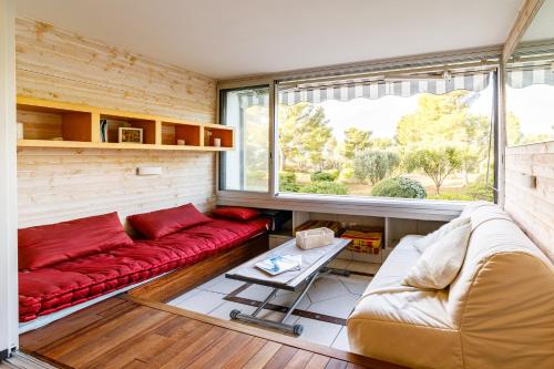 - un salon avec un canapé rouge et une fenêtre dans l'établissement Studio Bord de mer cadre exceptionnel, à Bandol