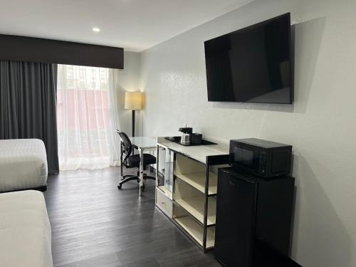 a hotel room with a desk with a television on the wall at Hotel Calle Joaquin - San Luis Obispo in San Luis Obispo