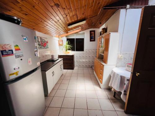 a kitchen with white appliances and a wooden ceiling at Casa Costa Ñuble in Cobquecura