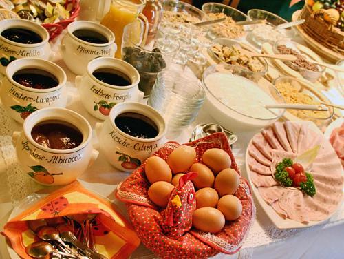 a table with eggs and cups of coffee and drinks at Hotel Schönbrunn in Merano