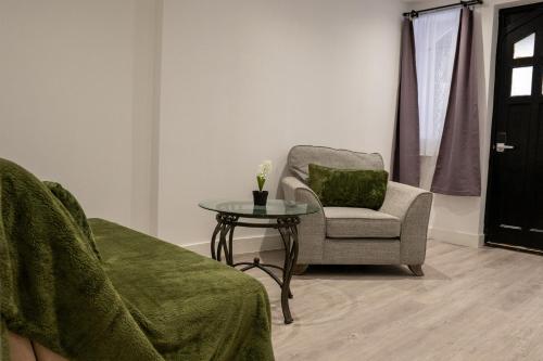 a living room with a chair and a table at Juniper Berry Apartments in Southampton