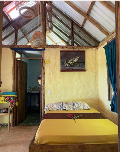a bedroom with a yellow bed in a room at Ecolodge el Arca Bahia Solano in Bahía Solano