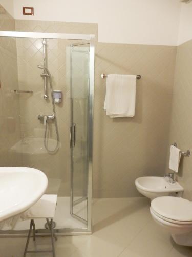 a bathroom with a shower and a toilet and a sink at Hotel Kaly in Ventimiglia