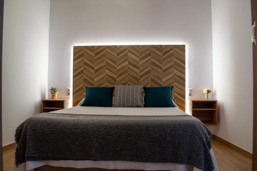 a bedroom with a large bed with blue pillows at Casa Rural Doña Sol in Montánchez