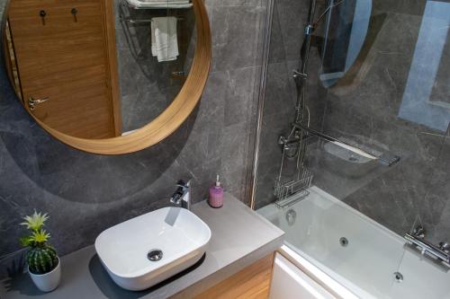 a bathroom with a sink and a mirror and a tub at Casa Rural Doña Sol in Montánchez