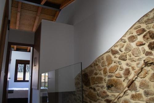 a room with a stone wall next to a door at Casa Rural Doña Sol in Montánchez