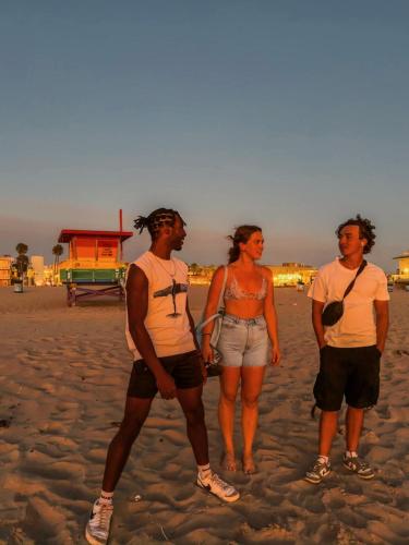 a group of three people standing on the beach at ITH Hermosa Beach Surf Hostel LAX in Hermosa Beach