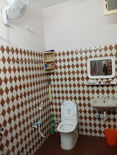 a bathroom with a toilet and a sink at Kallidai Home Stay Kumbakonam in Kumbakonam