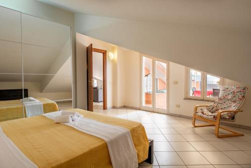 a bedroom with a bed and a chair in it at Case Vacanza Alega Mare in Nizza di Sicilia
