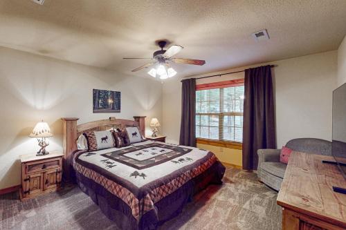 a bedroom with a bed and a couch and a ceiling fan at Lost Creek Haven in Branson West