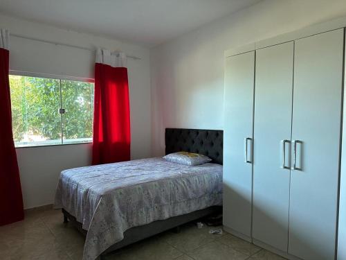 a bedroom with a bed and a dresser and a window at Casa de praia in Una