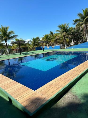a large swimming pool with a wooden deck at Casa de praia in Una