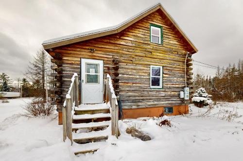 a log cabin in the snow with a door at Twin View Log Home in Carroll