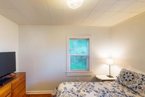 a bedroom with a bed and a tv and a window at Whale - Watcher's Perch in Depoe Bay