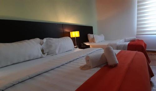 a hotel room with two beds and a lamp at Casa Coliving 121 in Bogotá