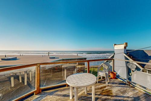 a balcony with a table and chairs on the beach at Sebastian's Crib Condo in Lincoln City