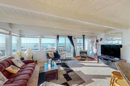 a living room with a couch and a television at Sebastian's Crib Condo in Lincoln City