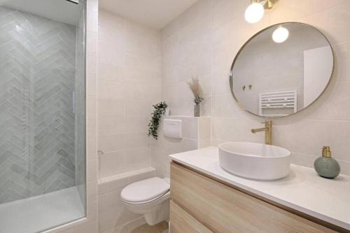 une salle de bain avec un lavabo, des toilettes et un miroir dans l'établissement Le Carré Vitriot apartment near Paris, à Vitry-sur-Seine