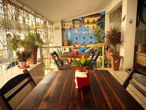 a dining room with a wooden table with plants on it at Solar dos Poetas in São Luís