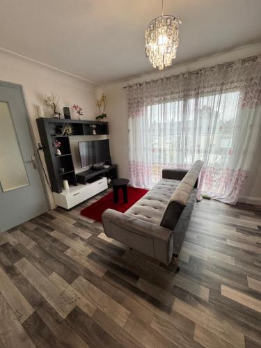 un salon avec un canapé et une télévision dans l'établissement Maison des rivages 3 chambres, à Saint-Géréon