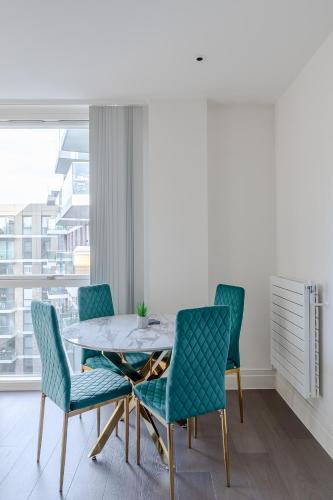 a dining room with a table and four chairs at Modern & Cosy Flat in Kingston in Kingston upon Thames